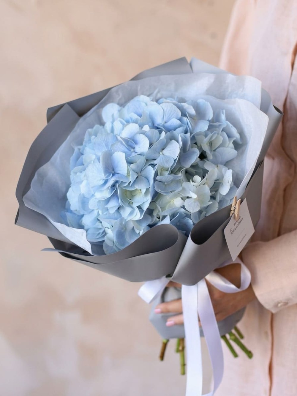 Bouquet with blue hydrangea in gray packaging