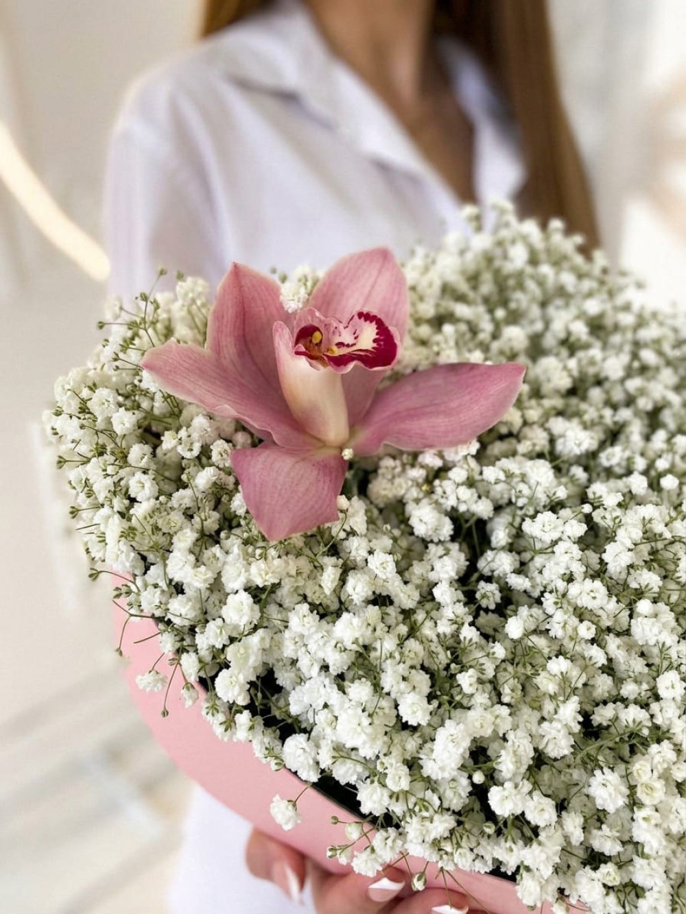 Compoziție din 9 ramuri de gypsophila albă cu o orhidee într-o cutie în formă de inimă