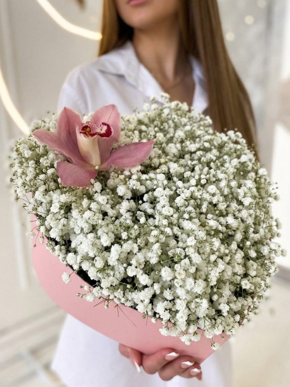 Compoziție din 9 ramuri de gypsophila albă cu o orhidee într-o cutie în formă de inimă