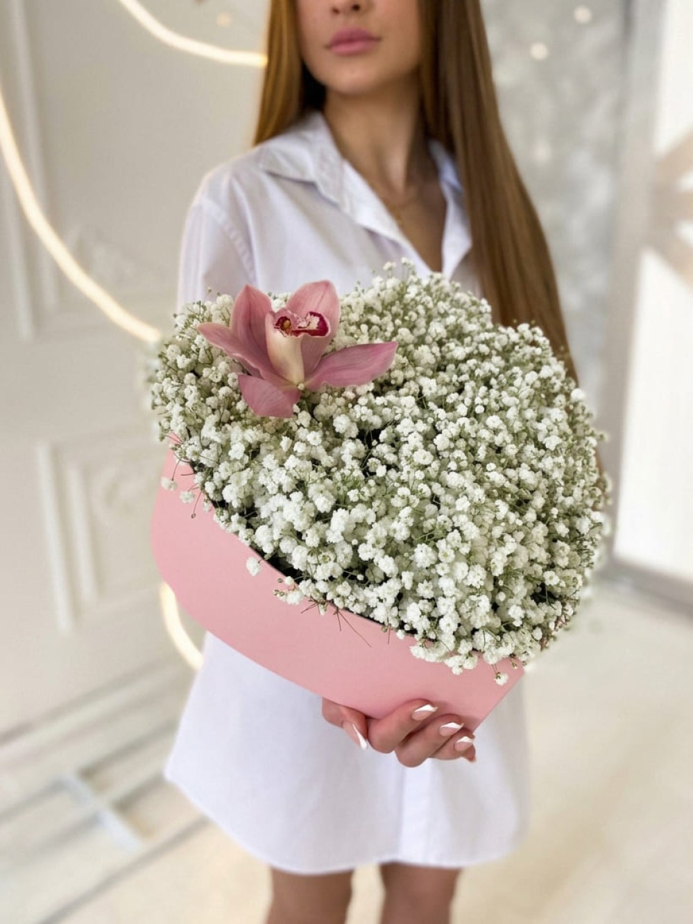 Compoziție din 9 ramuri de gypsophila albă cu o orhidee într-o cutie în formă de inimă