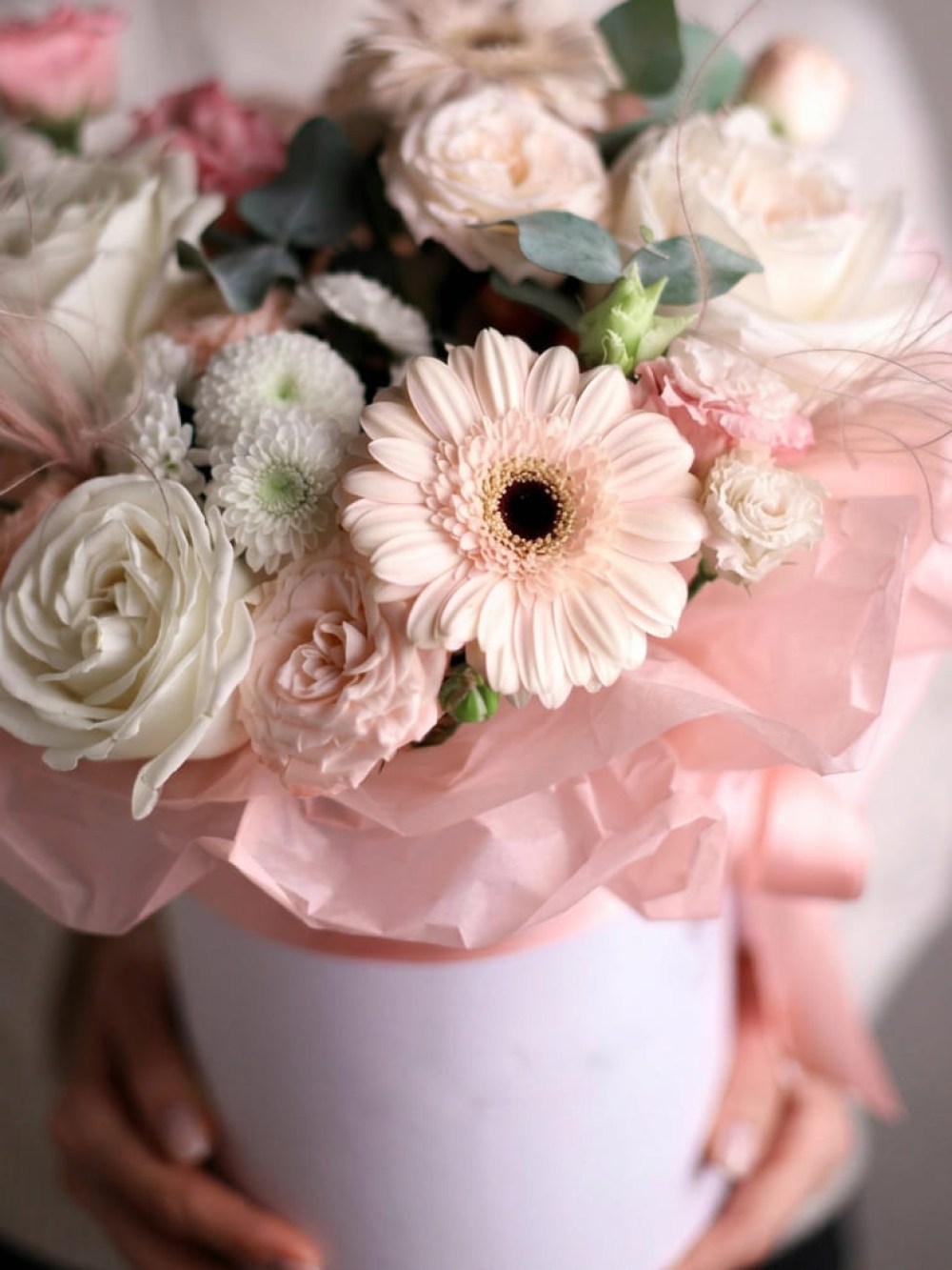 Compoziție de pudră cu gerbera într-o cutie cilindrică